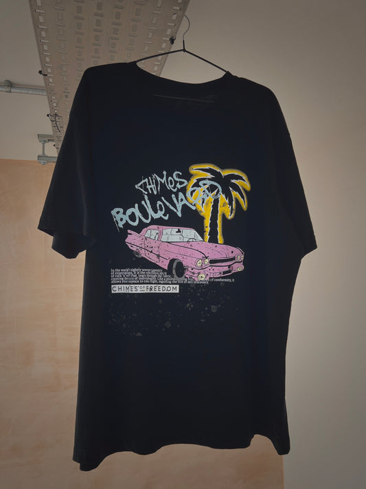 A hanging black t-shirt with a pink Cadillac design on