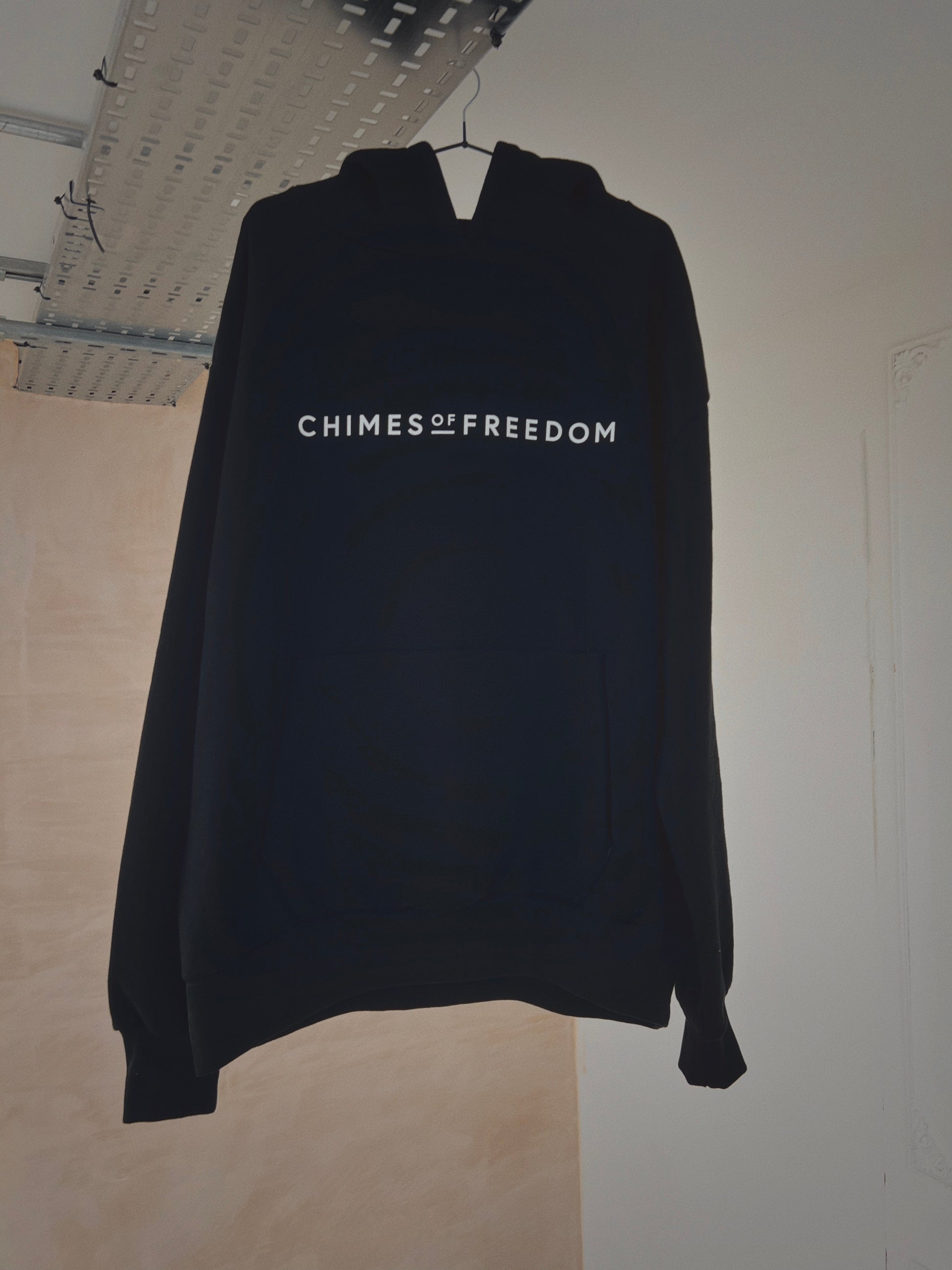 A hanging black oversized hoodie with slogan on